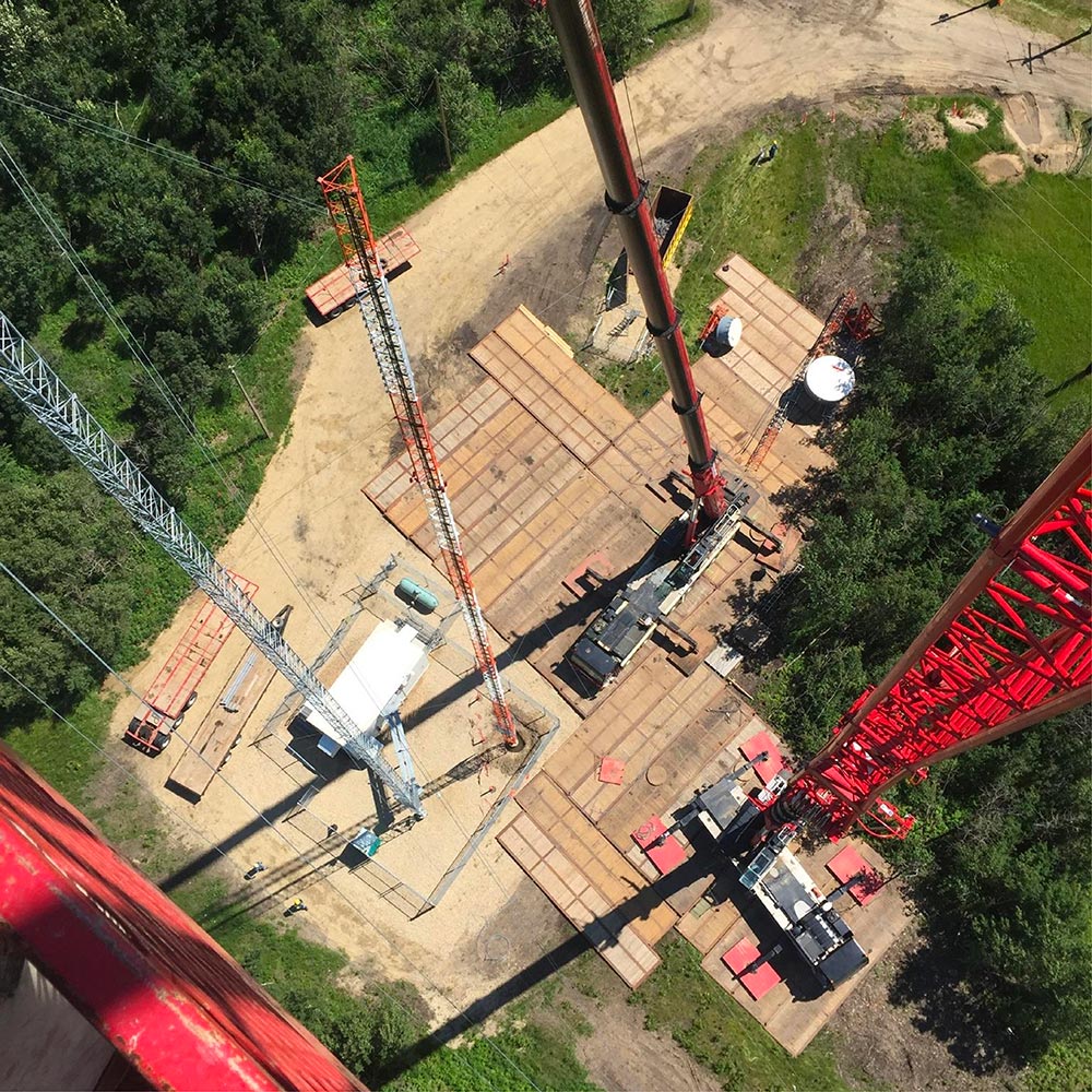 Vue aérienne d’un chantier d’installation de tour de télécommunication avec grues au Québec
